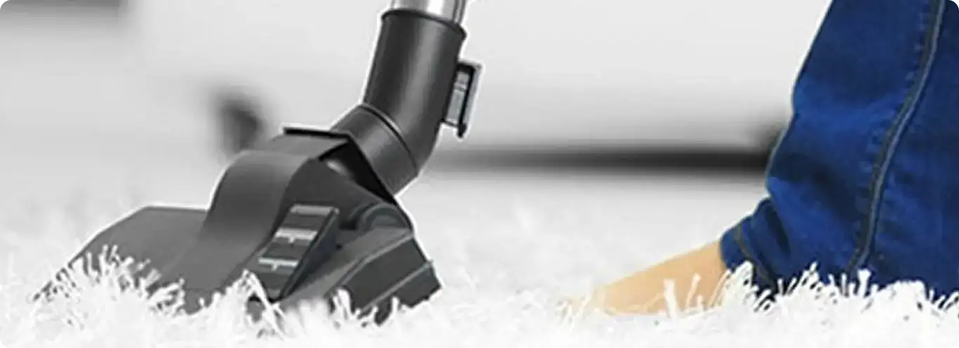 Close-up of a professional vacuuming a white carpet in Paragon.